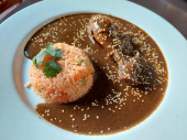 Un clásico de la gastronomía mexicana, pechuga de pollo bañada en mole poblano, servido con arroz rojo y tortillas de maíz. - Restaurante La Capilla de Atlixco