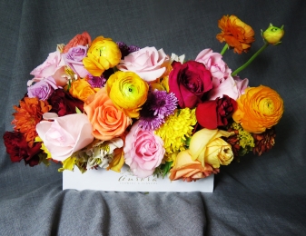 Arreglo floral en caja blanca Aurora Flowers & Co. combinación de rosas, ranunculus y flor de tempor...